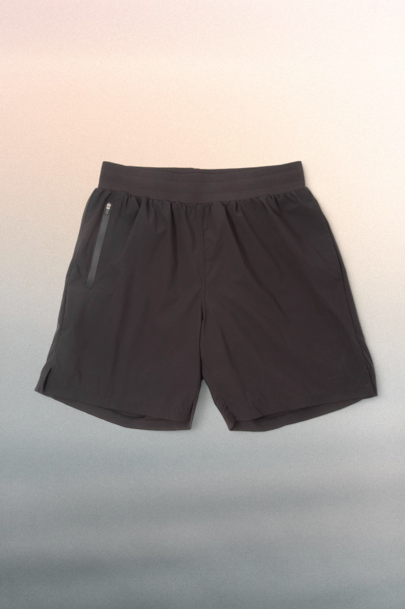 Black short with a black elastic waistband against a blue/pink gradient background.