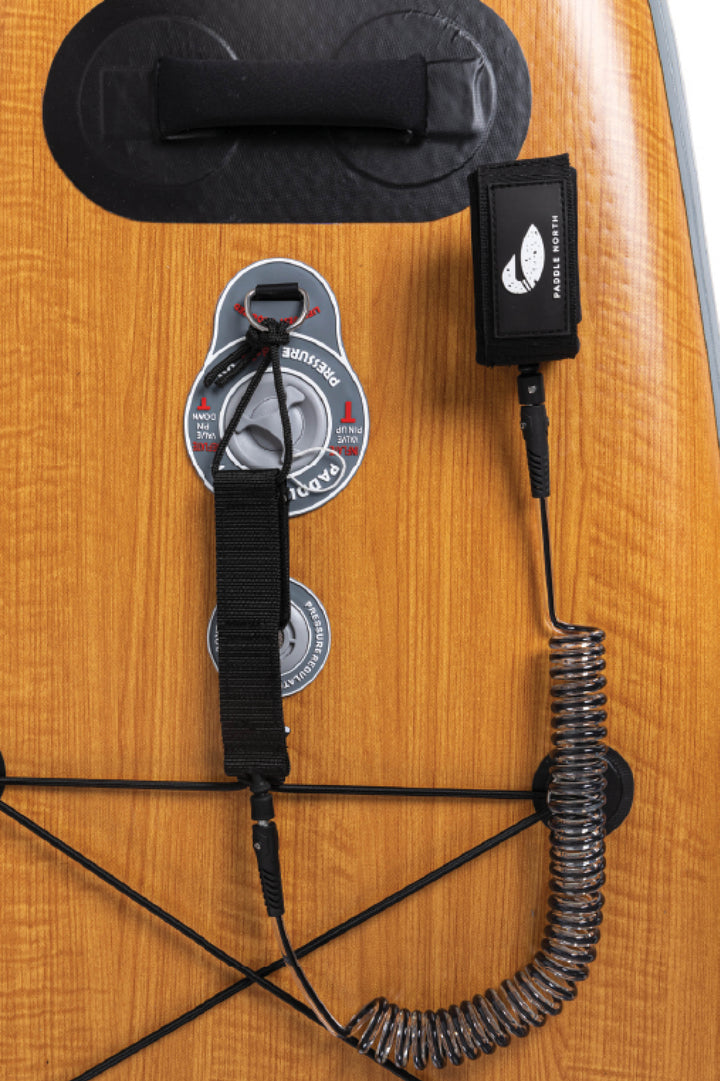 Paddle board accessories: Paddle North 10' SUP Leash sitting on an inflatable Paddle North paddle board.