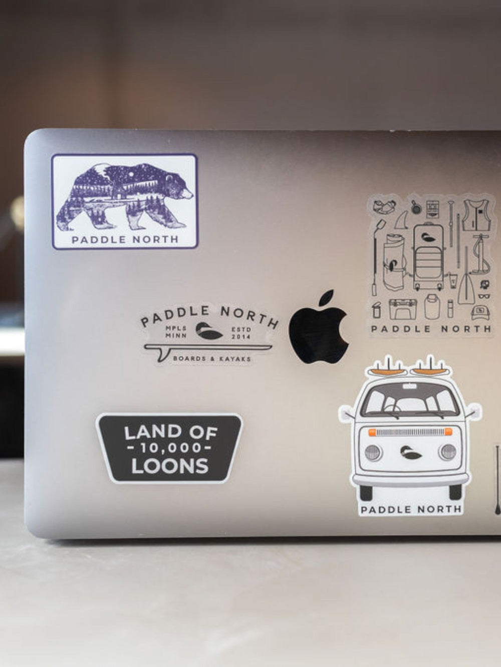 Macbook Laptop with assorted Paddle North stickers on it.