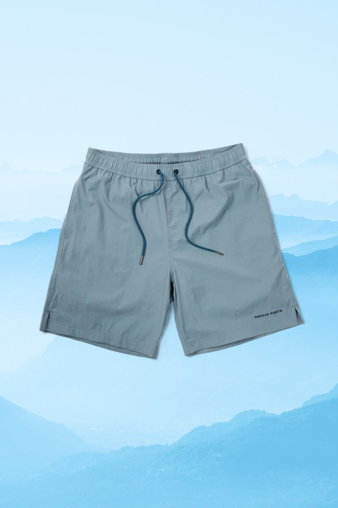 Pair of blue shorts against a blue mountainous background.