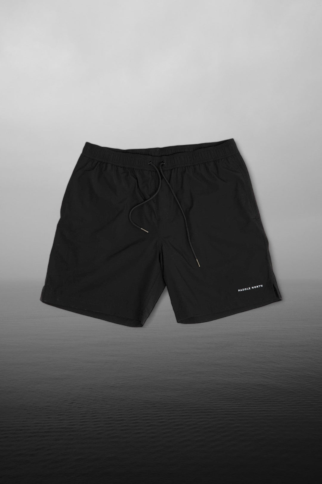 Pair of black shorts against a foggy lake photo background.