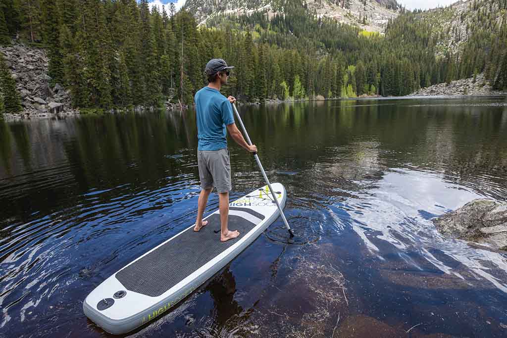 Man paddle boarding across lake