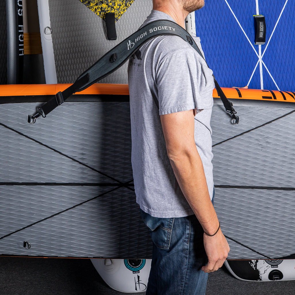 Man using the shoulder strap to carry a sup
